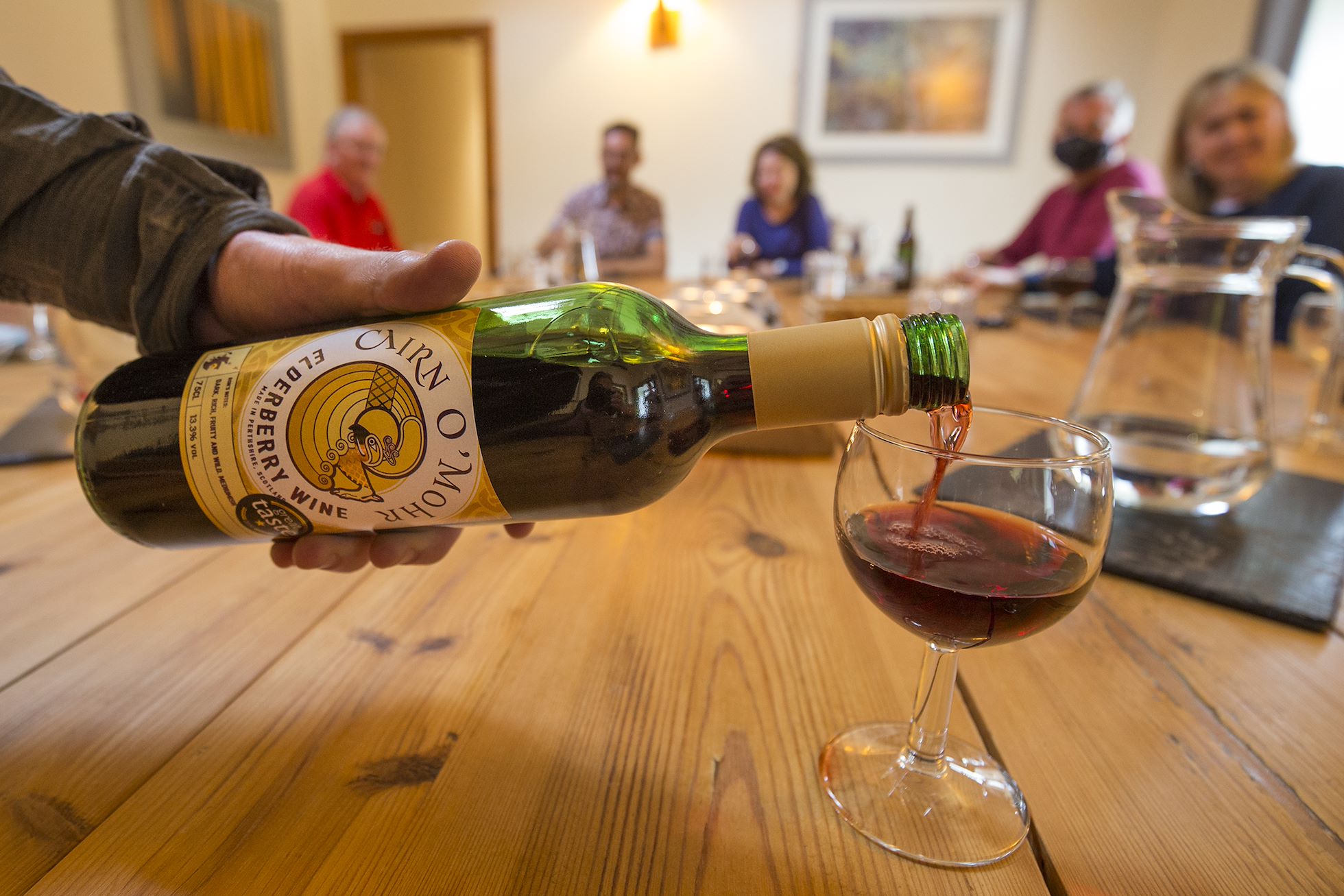 Cairn O' Mhor Scottish fruit wine being served to guests on rewilding retreat, Glenfeshie, Cairngorms National Park, Scotland.