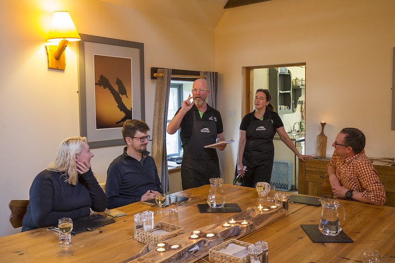 SCOTLAND: The Big Picture rewilding journey group at dining table with Ballintean catering team, Brian Munro and Wensy Sylvester, Cairngorms National Park, Scotland.