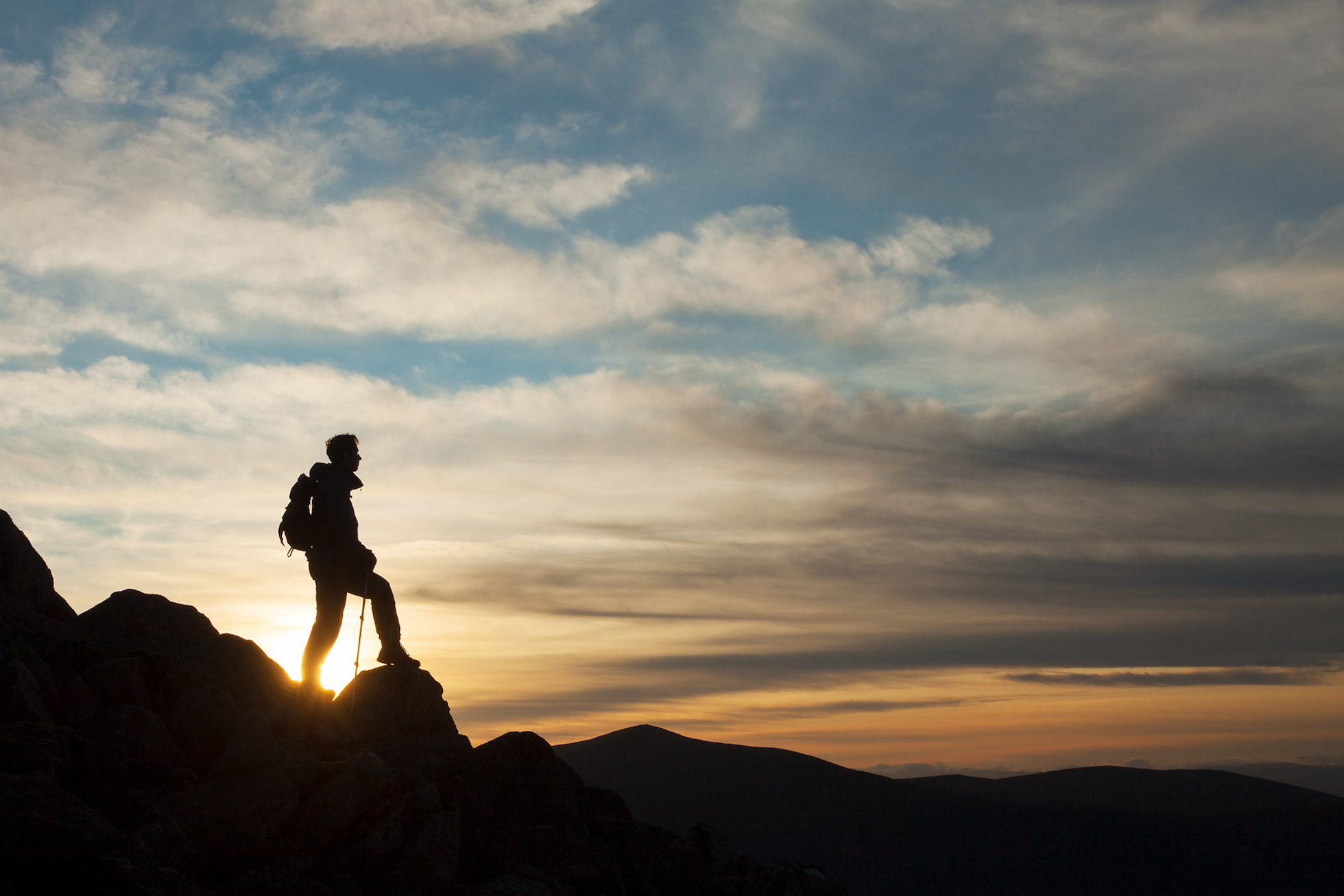 Walker silhouetted at sunset on Braeriach, Cairngorms National Park, Scotland