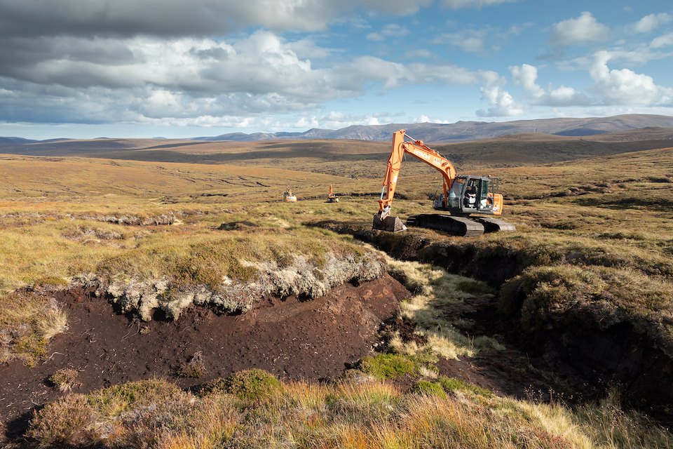 Excavator re-profiling eroded peat hags to help facilitate heather regeneration as part of peatland restoration work on An Lurg, September 2020, Cairngorms