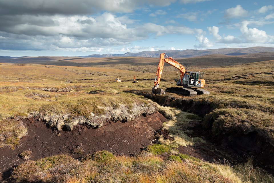 Excavator re-profiling eroded peat hags to help facilitate heather regeneration as part of peatland restoration work on An Lurg, September 2020, Cairngorms Excavator re-profiling eroded peat hags to help facilitate heather regeneration as part of peatland restoration work on An Lurg, September 2020, Cairngorms